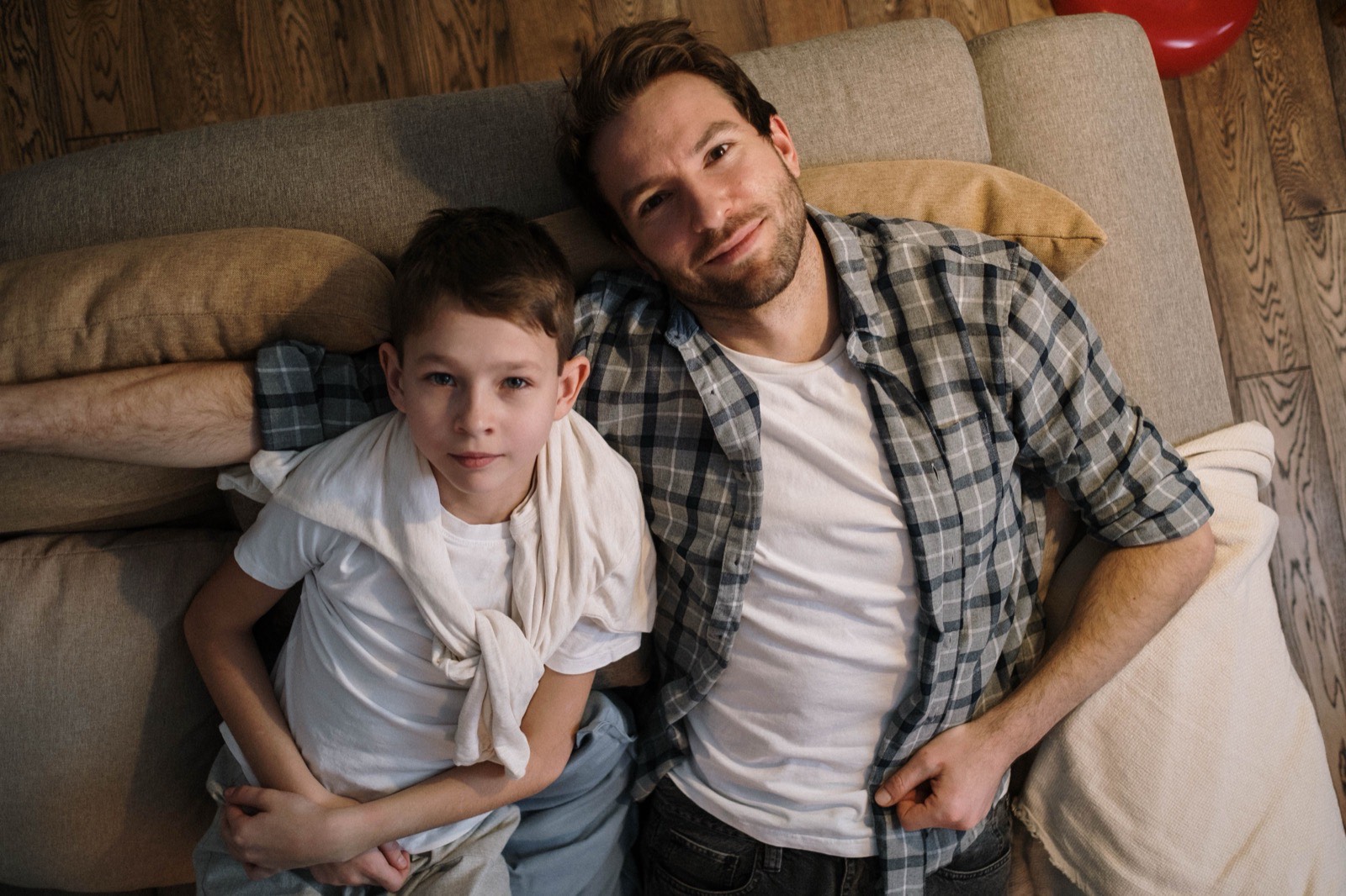 Father and son lying on a sofa looking up