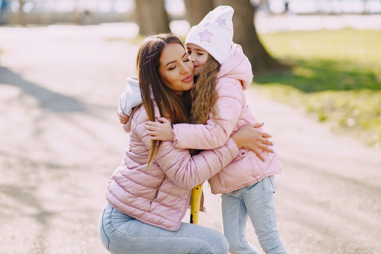 Mother and daughter hugging on a park path