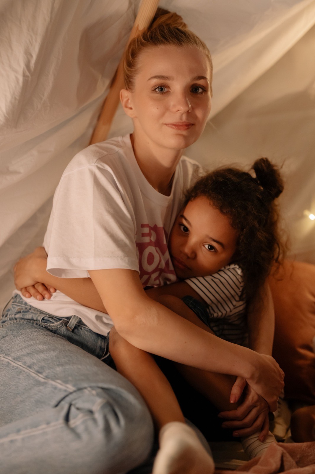 Mother and daughter sitting inside a play tent