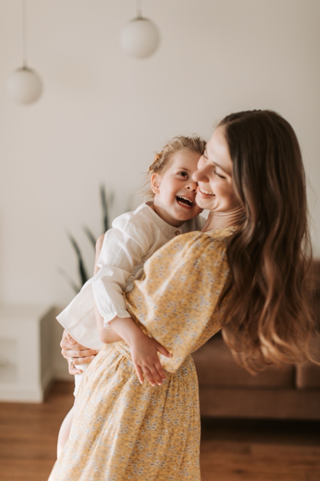 Woman holding a laughing toddler at home